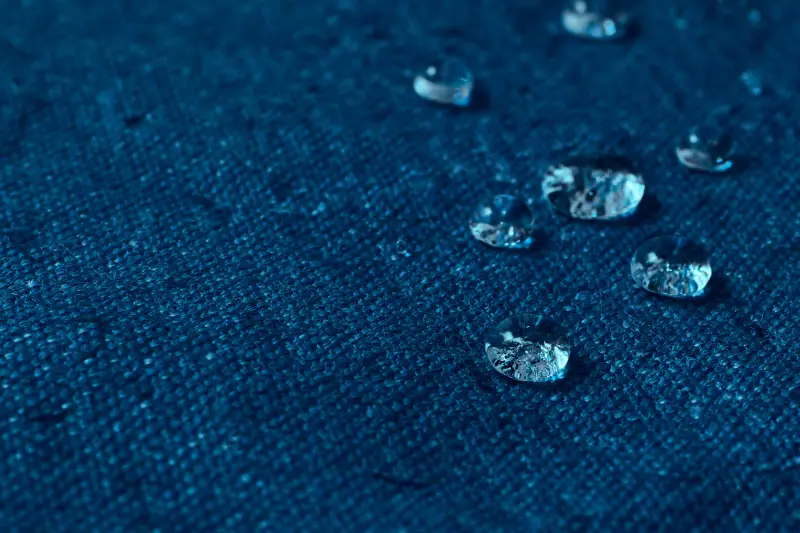 Water drops on blue waterproof fabric.
