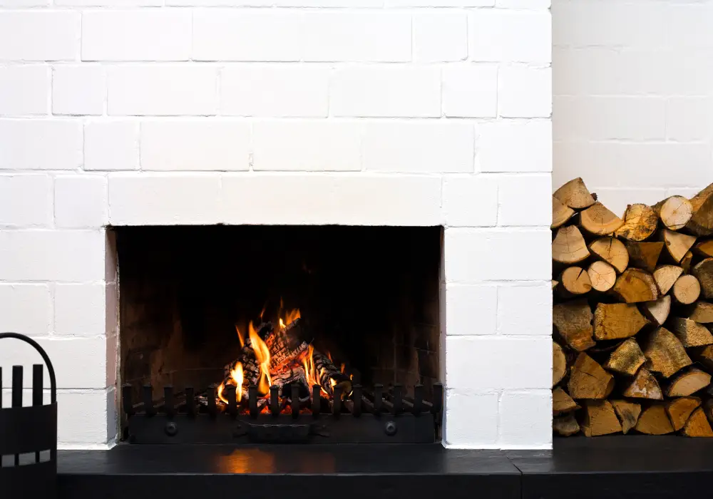 open fire-place in a living-room, stacked wood at side